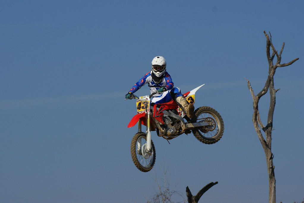 Honda rider getting big air beside the dead tree