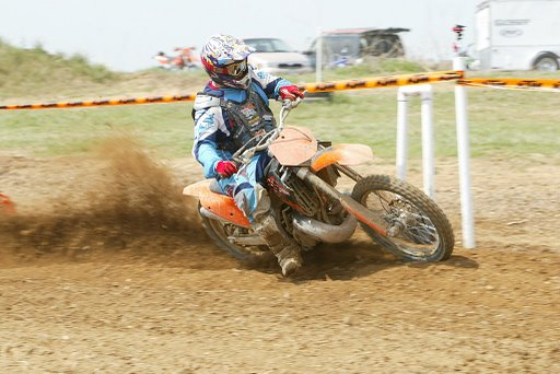 KTM rider roosting out of a corner