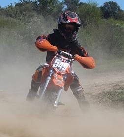 Young rider kicking up dust at Dirt Bike Boot Camp