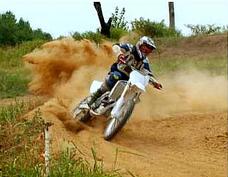 Rider throwing roost in a sandy corner